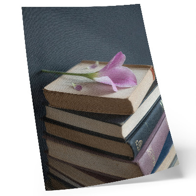 Hållbar väggposter En bunt böcker med en delikat blomma på toppen