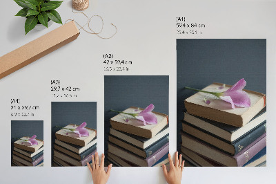 Hållbar väggposter En bunt böcker med en delikat blomma på toppen