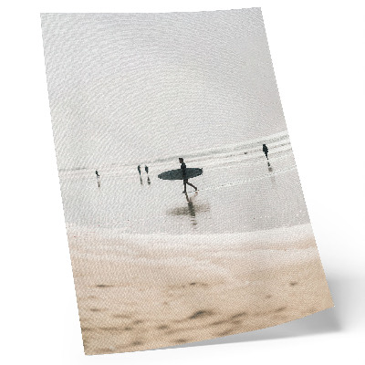 Affisch En surfare som går på stranden och bär en bräda