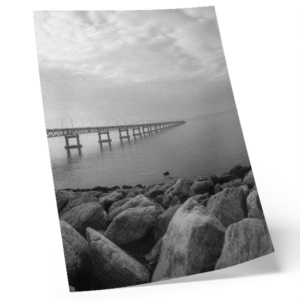 Hållbar väggposter Fridfullt landskap, bro, stenig strand, grå himmel