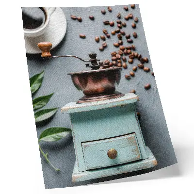 Dekorativ väggaffisch med motiv av gammal turkos kaffekvarn, kaffebönor och gröna blad
