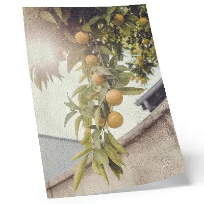 Dekorativ väggaffisch med motiv av trädgren med sol och gröna blad mot orange bakgrund
