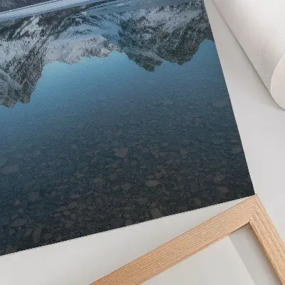 Väggaffisch med motiv av symmetriska vinterberg reflekterade i sjön