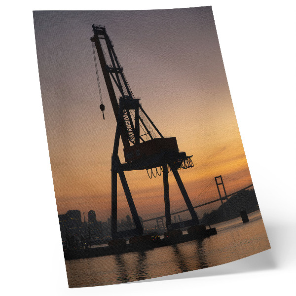 Hållbar väggposter Industriell kran silhuett solnedgång bro