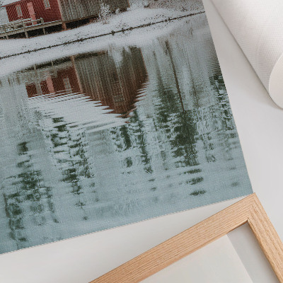 Affisch En röd stuga bland snötäckta träd vid vattnet