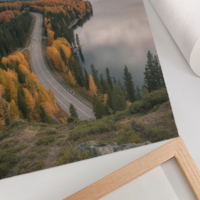 Hållbar väggposter En pittoresk väg bland träden bredvid sjön