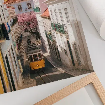 Poster en gata med spårvagn, pastellfärgade hyreshus och blommor