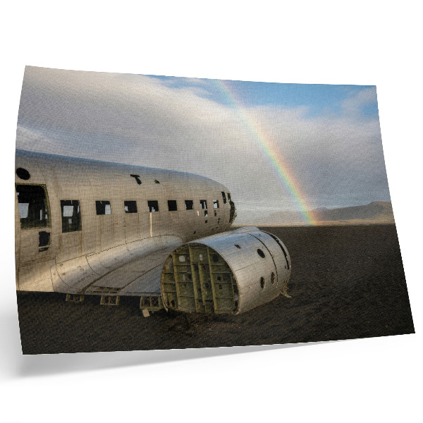 Stilren väggposter Ett metalliskt flygplansvrak med en regnbåge i bakgrunden.