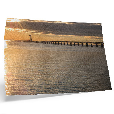 Väggposter En bro vid horisonten upplyst av solen