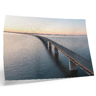 Väggposter En bro över ett lugnt hav vid solnedgången