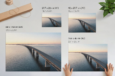 Väggposter En bro över ett lugnt hav vid solnedgången