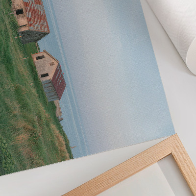 Väggposter Rustika byggnader gröna ängar hav