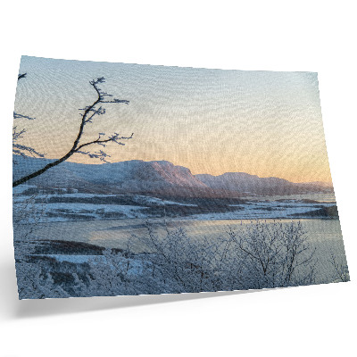 Poster Vinterlandskap med berg, vatten, träd i skymningen