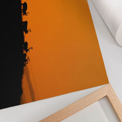 Väggposter Silhuetter av rådjur på en kulle med orange bakgrund