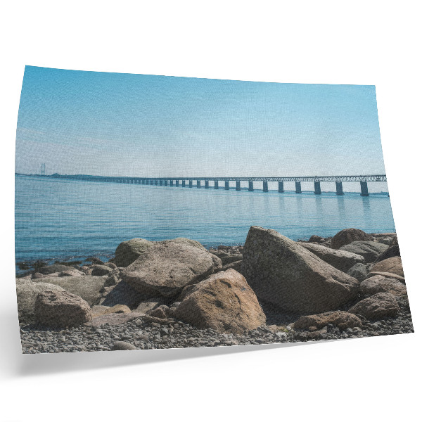 Stilren väggposter Bro över blå vattenstenar på stranden