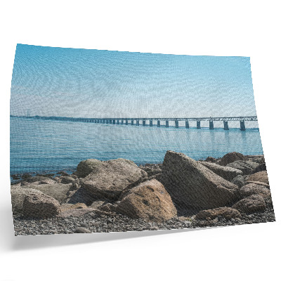 Stilren väggposter Bro över blå vattenstenar på stranden