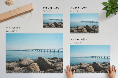 Stilren väggposter Bro över blå vattenstenar på stranden