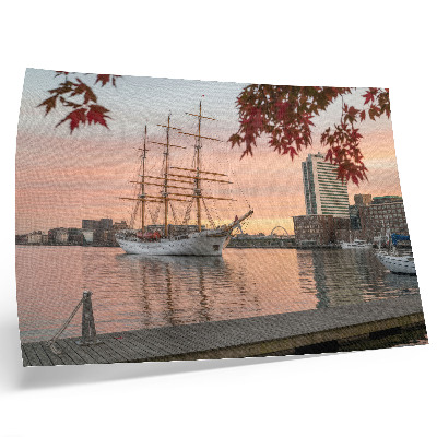 Väggposter Ett segelfartyg vid solnedgången, ett fridfullt panorama över staden