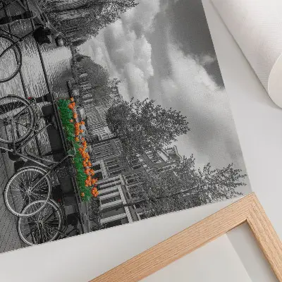 Väggposter charmig vy över kanal med cyklar och tulpaner i svart och orange