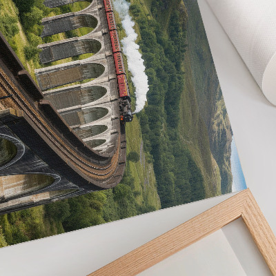 Väggposter En viadukt med ett tåg bland gröna kullar