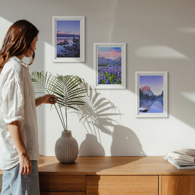 Triptyk tavla med ram Berglandskap med vatten, himmel och ett fält av blommor