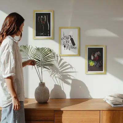 Tavelvägg med 3 tavlor med motiv av vinglas och druvor samt text om vin