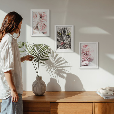 Tavelvägg med 3 tavlor En katt bland rosa blommor av rosor och pioner