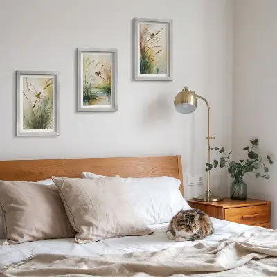 Tavelvägg med 3 tavlor med motiv av trollsländor bland gräset vid vattnet i målerisk stil