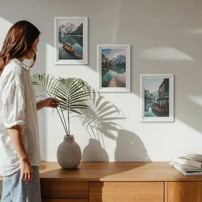 Tavelvägg med 3 tavlor motiv av en sjö i bergen med båtar och en träkoja
