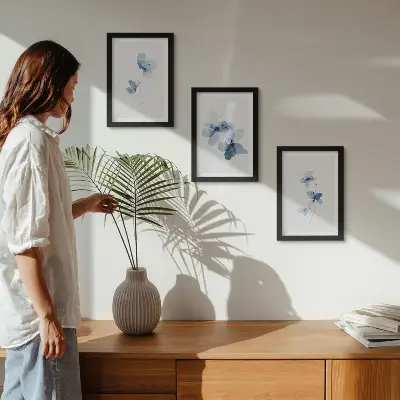 Tavelvägg med 3 tavlor motiv med blommor i blå nyanser mot ljus bakgrund