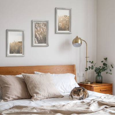 Tavelvägg med 3 tavlor Ett landskap med gräs och blommor i varma nyanser