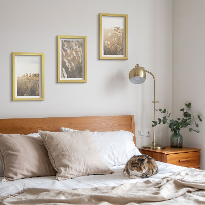 Tavelvägg med 3 tavlor Ett landskap med gräs och blommor i varma nyanser
