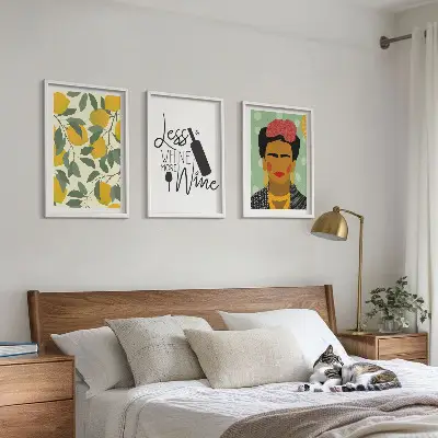 Tavelset med motiv av citroner och vin porträtt av Frida för väggen ovanför soffan