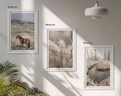 Tavelset ovanför soffa med motiv av hästar i ett landskap med gräs och bäck