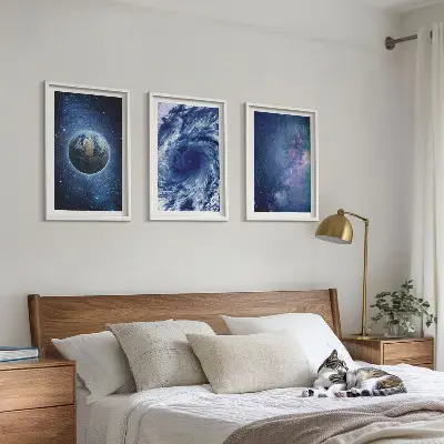 Tavelset ovanför soffa med motiv av jordklotet i en galaktisk rymdstorm