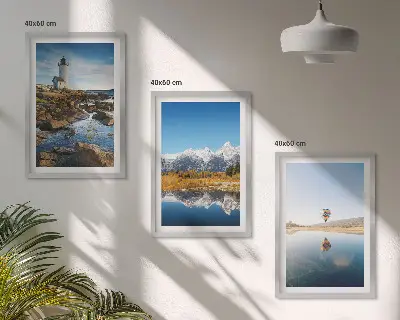 Tavelset ovanför soffan med motiv av natur, fyr, berg och luftballong