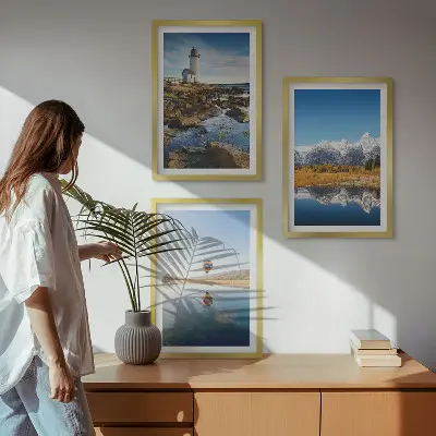 Tavelset ovanför soffan med motiv av natur, fyr, berg och luftballong