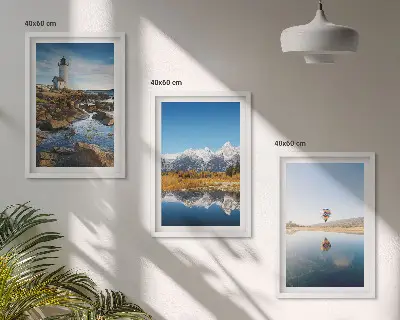 Tavelset ovanför soffan med motiv av natur, fyr, berg och luftballong