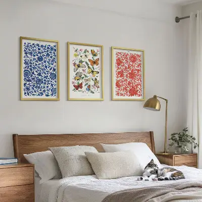 Tavelset ovanför soffan med motiv av vintage blommor och fjärilar