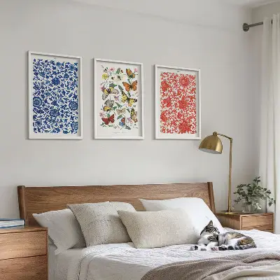 Tavelset ovanför soffan med motiv av vintage blommor och fjärilar