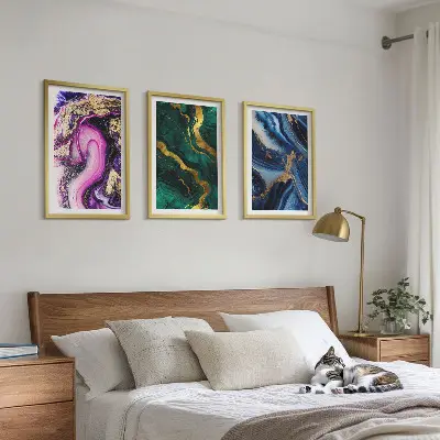 Tavelset ovanför soffa med abstrakta rosgröna mönster