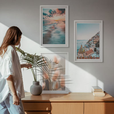 Tavelset ovanför soffa Havssolnedgång hus blommor