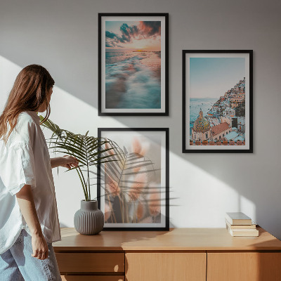 Tavelset ovanför soffa Havssolnedgång hus blommor