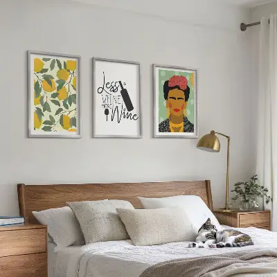 Tavelset ovanför soffa med citroner och vinporträtt av Frida