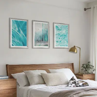 Tavelset ovanför soffa med abstrakta mönster i blå nyanser