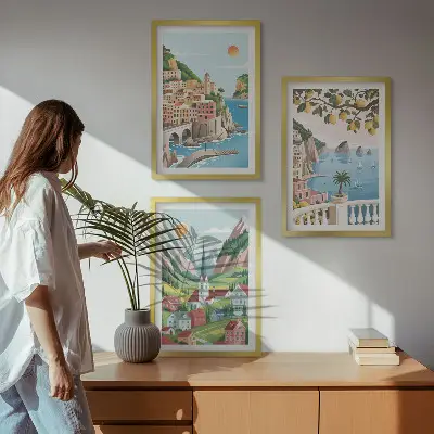 Tavelset ovanför soffa med motiv av landskap, hav och citrusfrukter