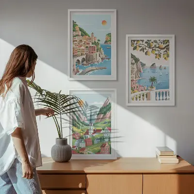 Tavelset ovanför soffa med motiv av landskap, hav och citrusfrukter