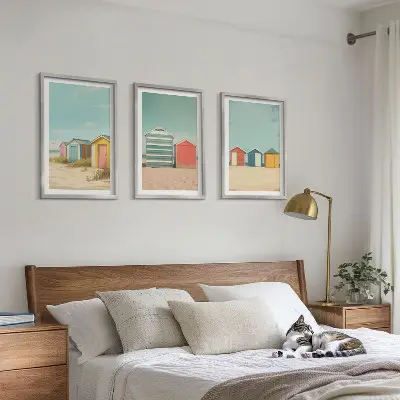 Tavelset med ramar färgglada hus vid stranden i solsken