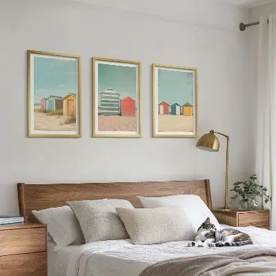 Tavelset med ramar färgglada hus vid stranden i solsken