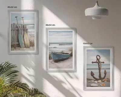 Tavelset ovanför soffa med motiv av strand, båt, ankare och sand